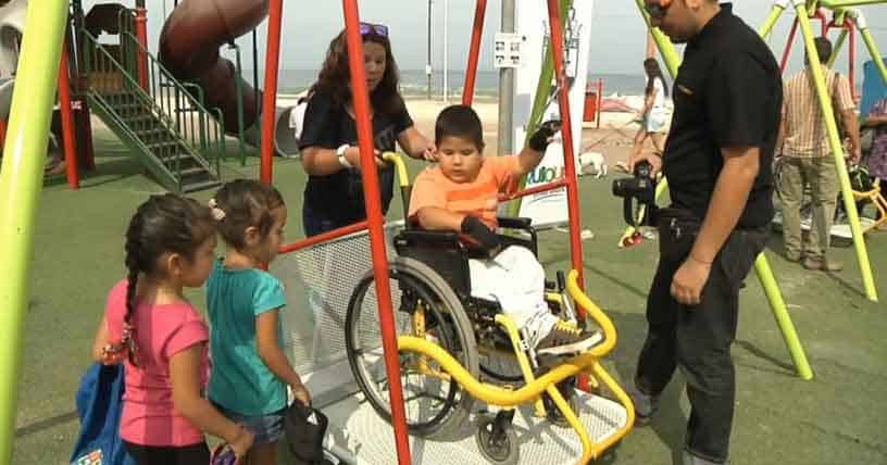 Niño columpiándose en una plaza accesible.
