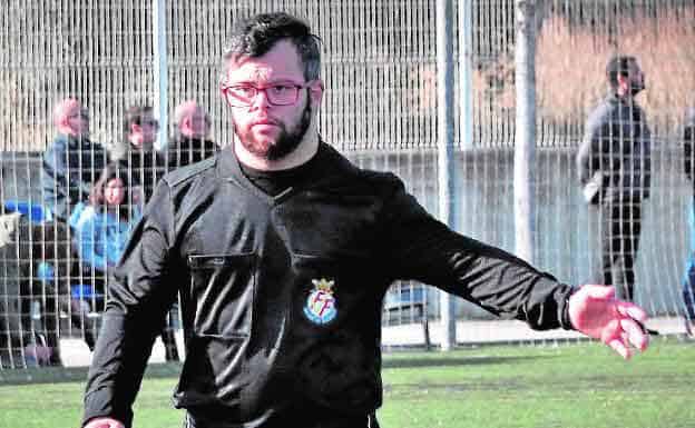 un joven con síndrome de Down arbitrando un partido en fútbol.