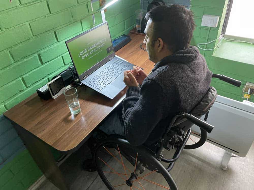 Hombre en silla de ruedas frente a un computador