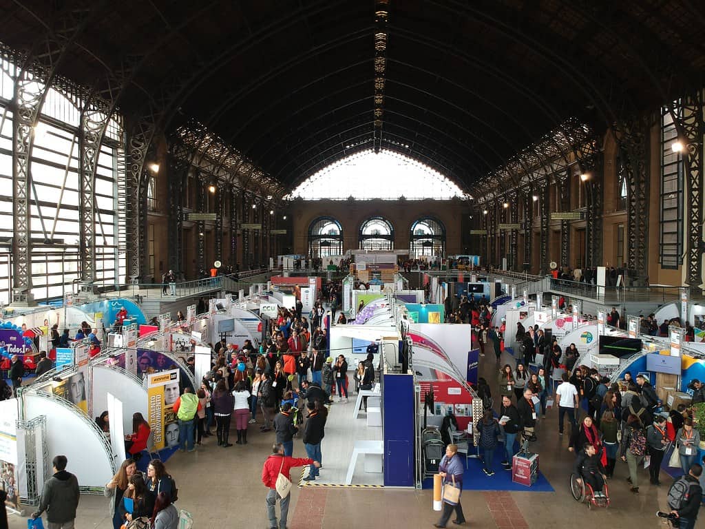 Foto de la estación mapocho por dentro durante una expo el año 2018 donde hay muchos stand y gente caminando y en silla de ruedas.