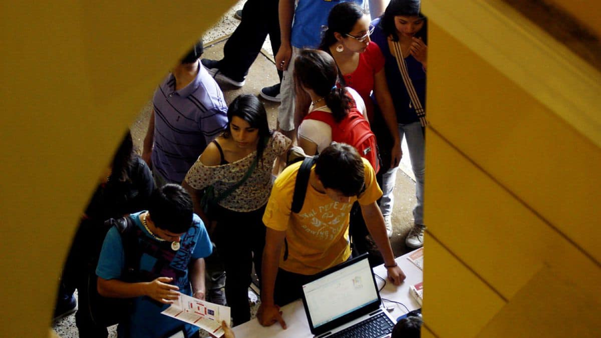 Foto de un grupo de jóvenes haciendo una fila para realizar una postulación en una universidad