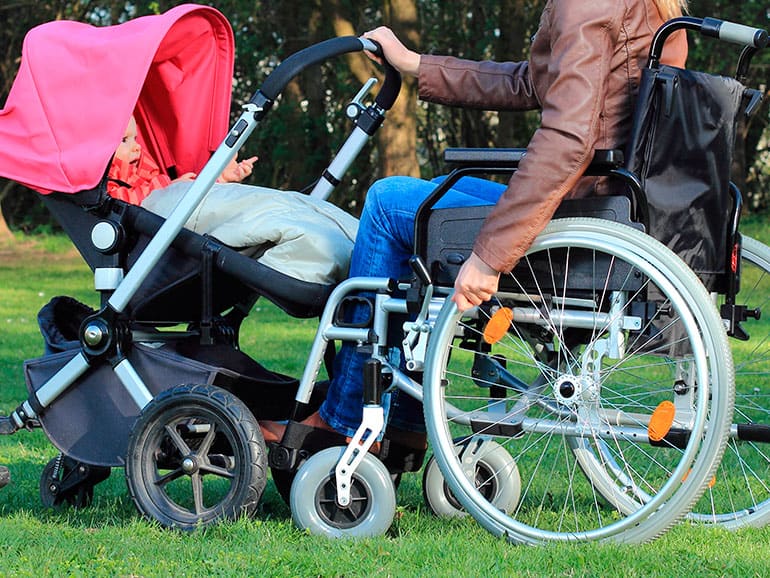 madre en silla de ruedas con su bebe en un coche