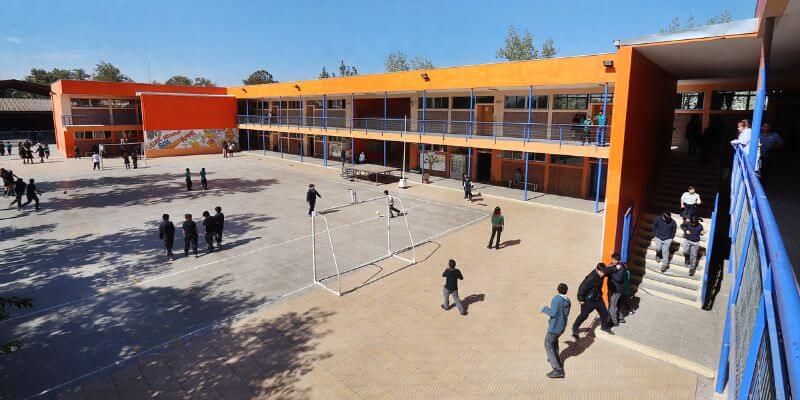 Foto general del patio de una escuela en chile donde se ven algunos estudiantes paseando.