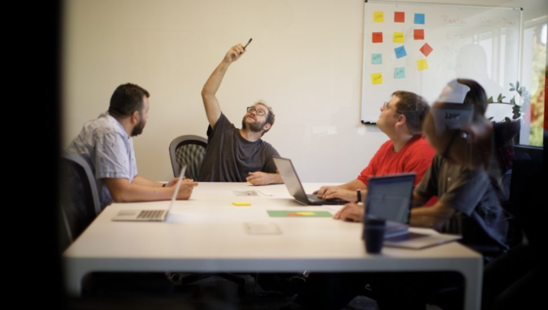 Un grupo de trabajadores autistas reunidos en una oficina de trabajo.