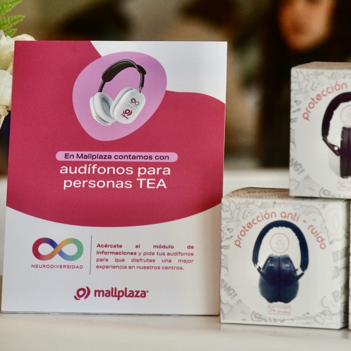 Foto de un cartel colocado sobre un mesón de atención al cliente y que dice "audífonos para personas TEA"