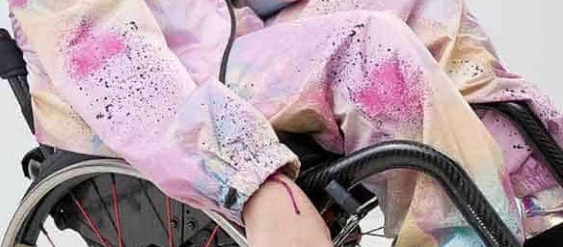 Una mujer en silla de ruedas sonríe a la cámara.