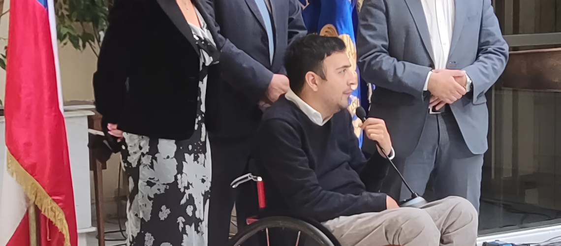 Foto en el congreso nacional donde aparecen 3 diputados de pie junto a una persona en silla de ruedas hablando a la prensa.