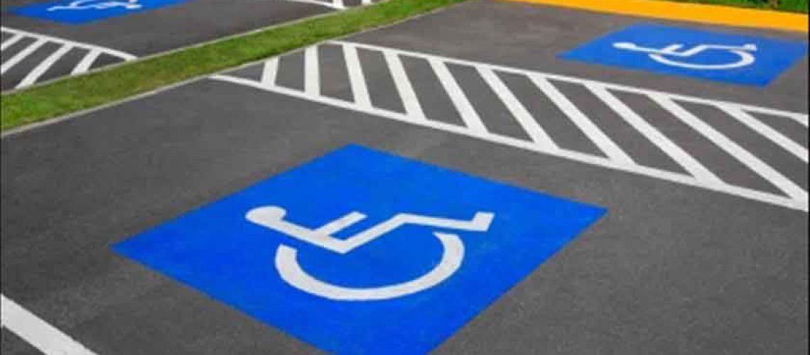 Foto de varios estacionamientos azules con el símbolo de la discapacidad, indicando que están reservados
