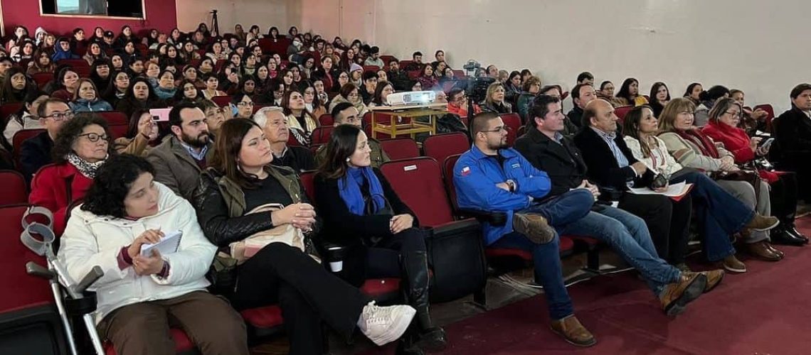 Foto dentro de un auditorio de un instituto donde aparecen casi todos los asientos ocupados con personas que están atentas a la charla.