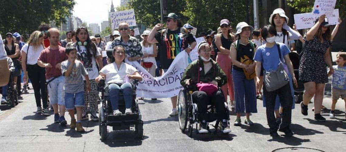 Foto de un grupo de personas con diversos tipos de discapacidad marchando por la alameda en santiago.