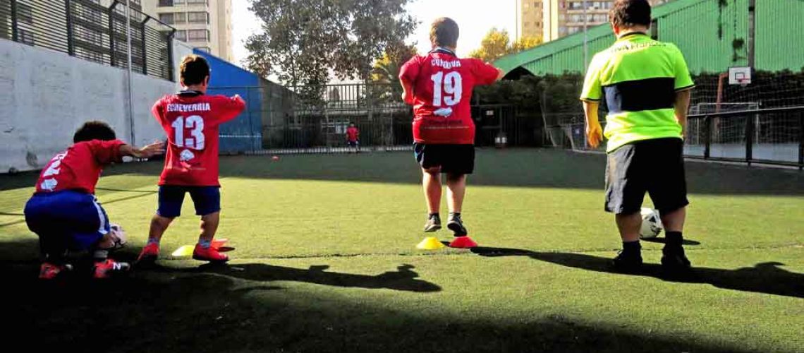 Algunos jugadores de la selección chilena de fútbol talla baja entrenan en una cancha de pasto.