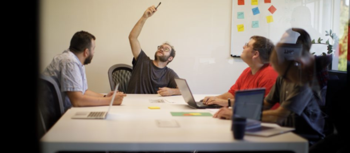Un grupo de trabajadores autistas reunidos en una oficina de trabajo.