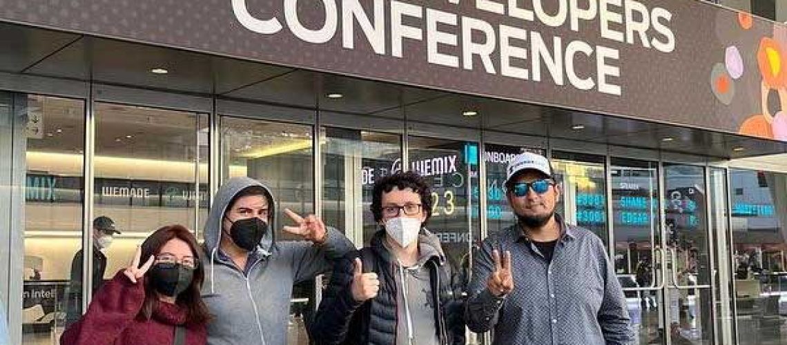 Foto de un grupo de cuatro personas de la empresa Dreams of Heaven afuera del edificio que dice Game Developers Conference en Estados Unidos.