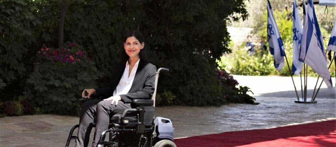 Una mujer en silla de ruedas sobre una alfombra roja