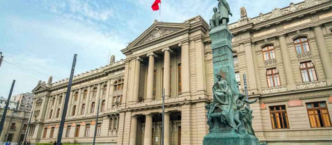 foto de la fachada del edificio de la Corte Suprema de Chile y se alcanza a apreciar un parte del cielo celeste. Hay un cuadro blanco que dice: Corte Suprema declara que síndrome de Down no es una enfermedad y ordena dar cobertura de salud.