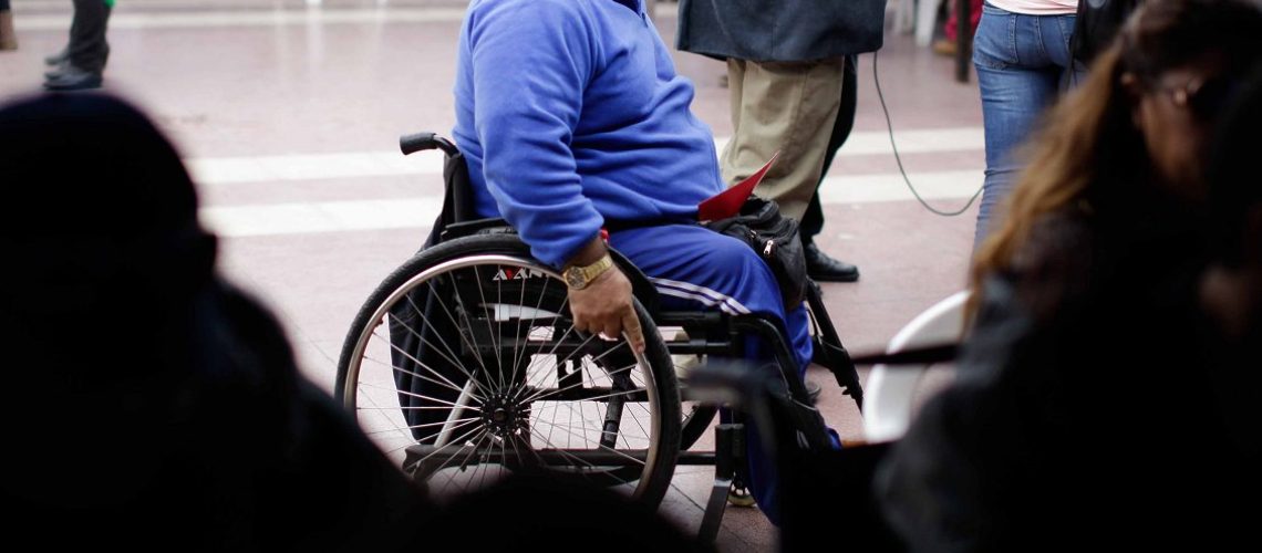 Foto de una persona en silla de rudas en una calle de santiago