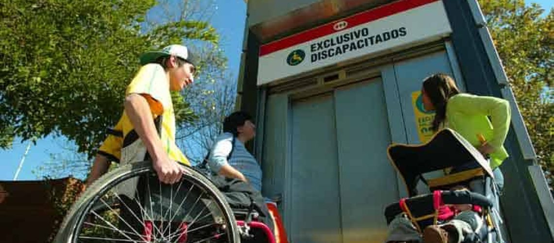 Foto donde aparece una persona en silla de ruedas esperando el ascensor para entrar al Metro de Santiago.