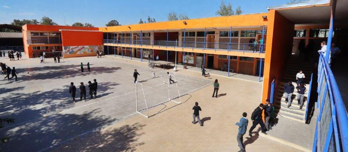 Foto general del patio de una escuela en chile donde se ven algunos estudiantes paseando.
