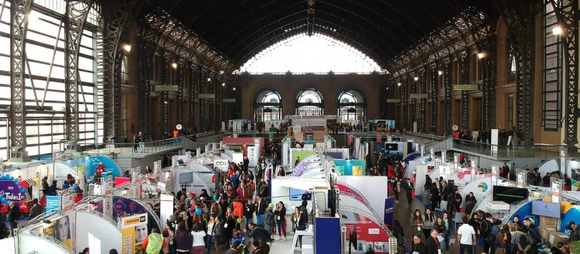 Foto de la estación mapocho por dentro durante una expo el año 2018 donde hay muchos stand y gente caminando y en silla de ruedas.
