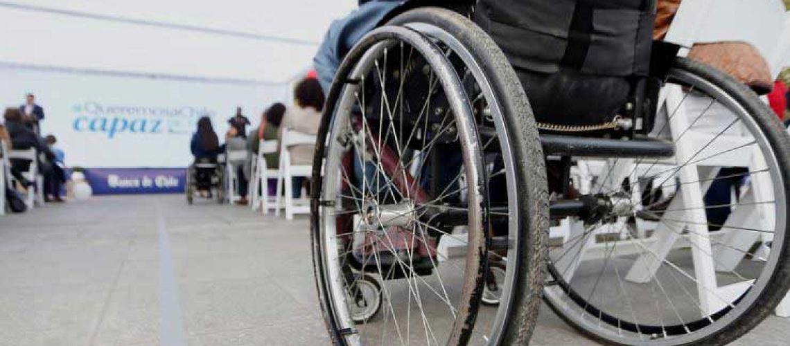 Foto de una persona en silla de ruedas y está sacada desde abajo, dándole más protagonismo a la rueda