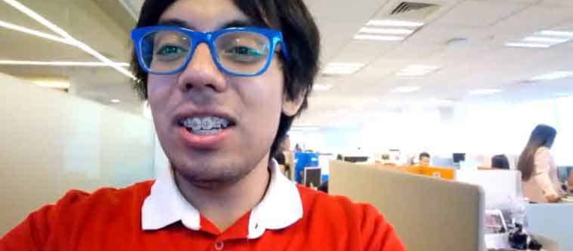 Joven con asperger se saca una foto en modo selfie dentro de la oficina donde realizó su práctica profesional.
