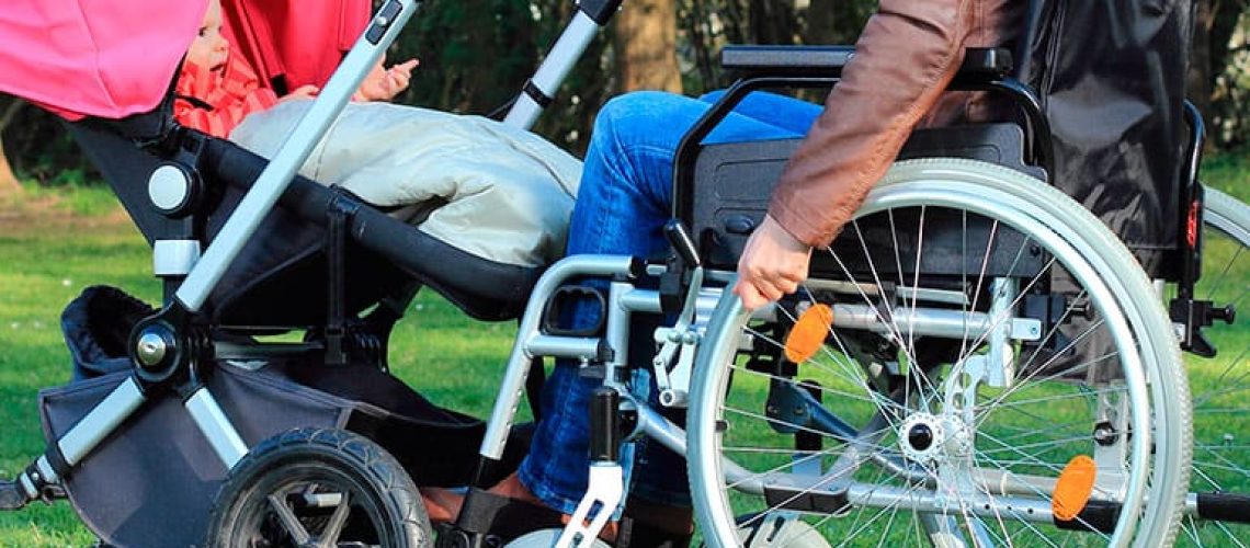 madre en silla de ruedas con su bebe en un coche
