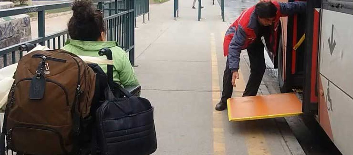 Conductor de transantiago habilitando rampa y persona en silla de ruedas