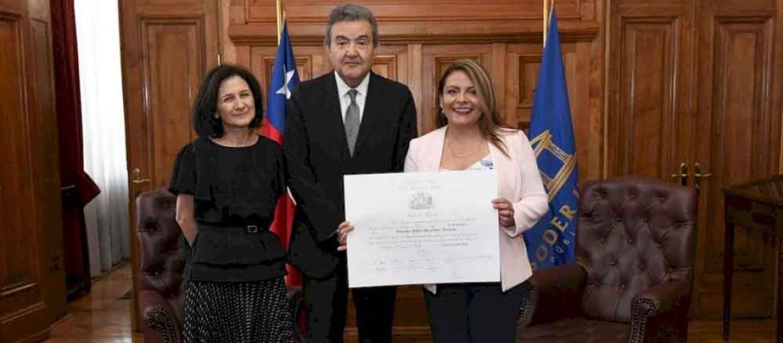 Una mujer sorda aparece con su diploma del título profesional de abogada.