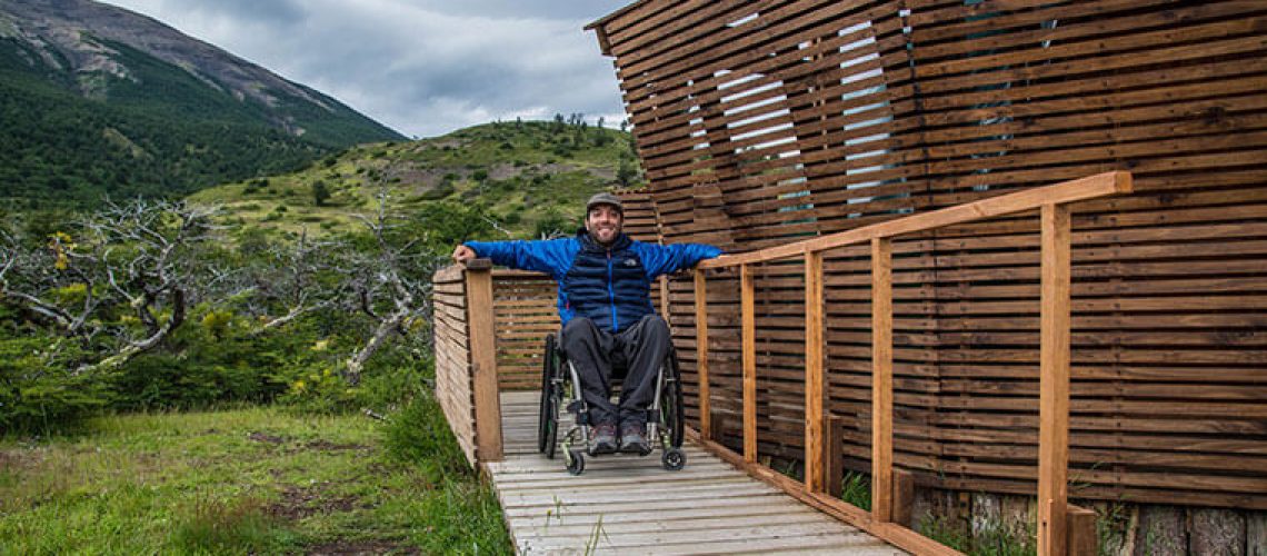 Foto de una persona en silla de rudas sobre un sendero accesible en un parque nacional.